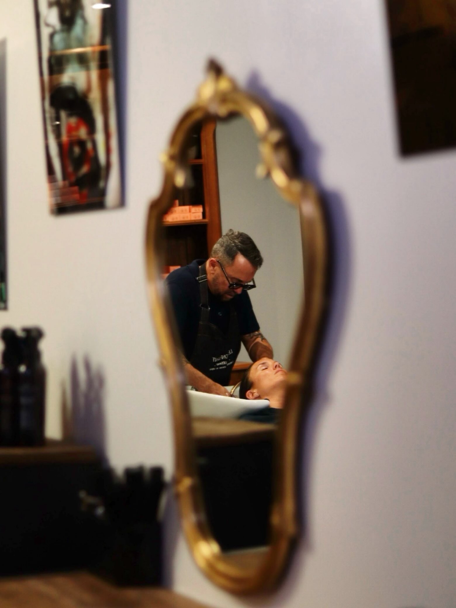 Soin du cheveu au bac dans le salon Le Confident à Toulon, vu dans un miroir.